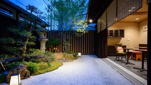 A traditional Japanese-style garden with a gravel path, rocks, and plants. - Luck You Kyoto (Kyoto)