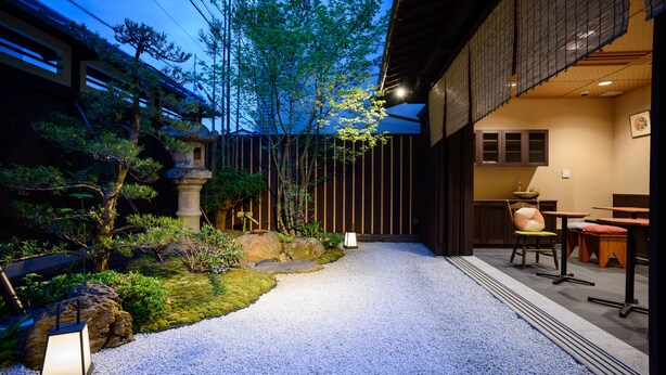 A traditional Japanese-style garden with a gravel path, rocks, and plants. - Luck You Kyoto (Kyoto)