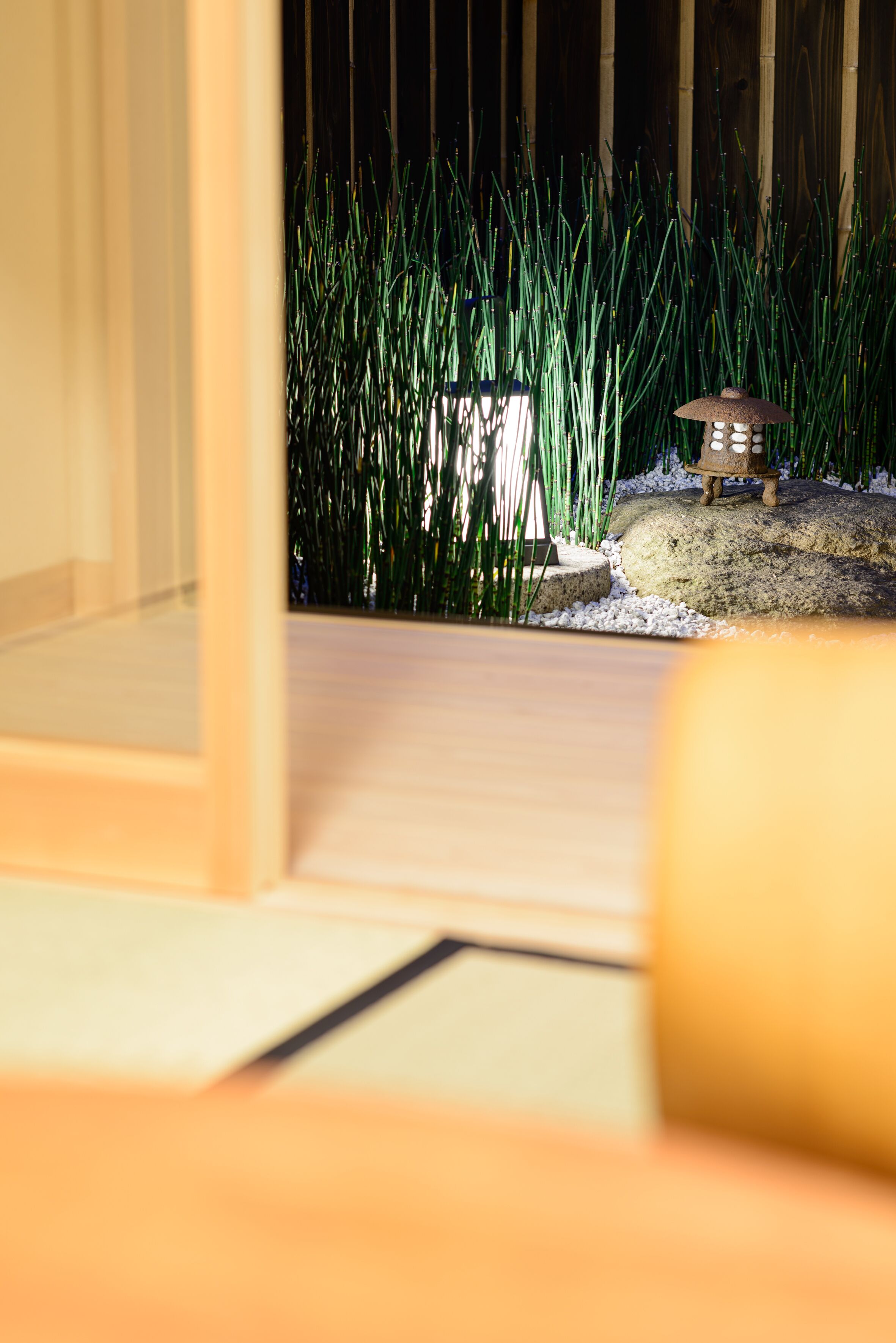 A wooden floor with a small decorative item on a rock.