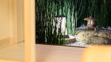 A wooden floor with a small decorative item on a rock.