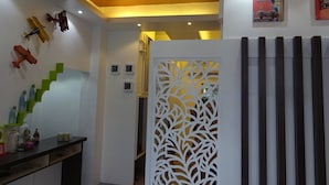 A modern interior with a staircase, decorative wall clocks, and a patterned partition. - Shejoje Poshtel Hostel (Cebu City)