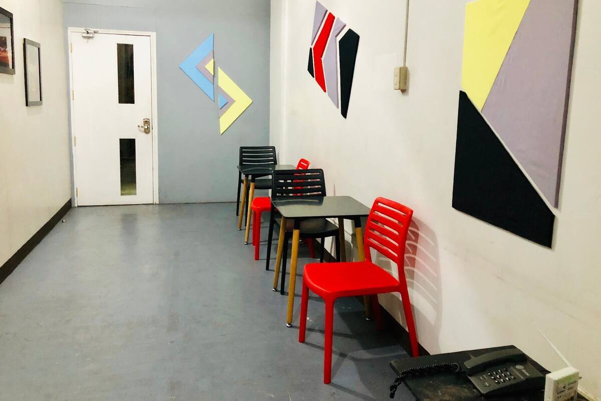 A hallway with a table and chairs, a door, and abstract wall art.