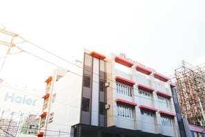A multi-story hotel with a modern facade, including a prominent sign for 'Haier' and 'Hotel Town'.