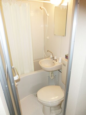 A small, compact bathroom with a toilet, sink, and shower. - BK Hotel & Weekly (Wakayama)
