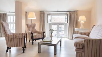 A room with striped armchairs, a coffee table, and lamps.