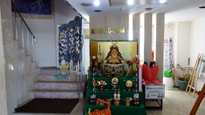 A staircase leading to a reception area with a 'WELCOME' sign, a display of trophies, and a tiger statue. - Sea Queen Kainan (Kainan)