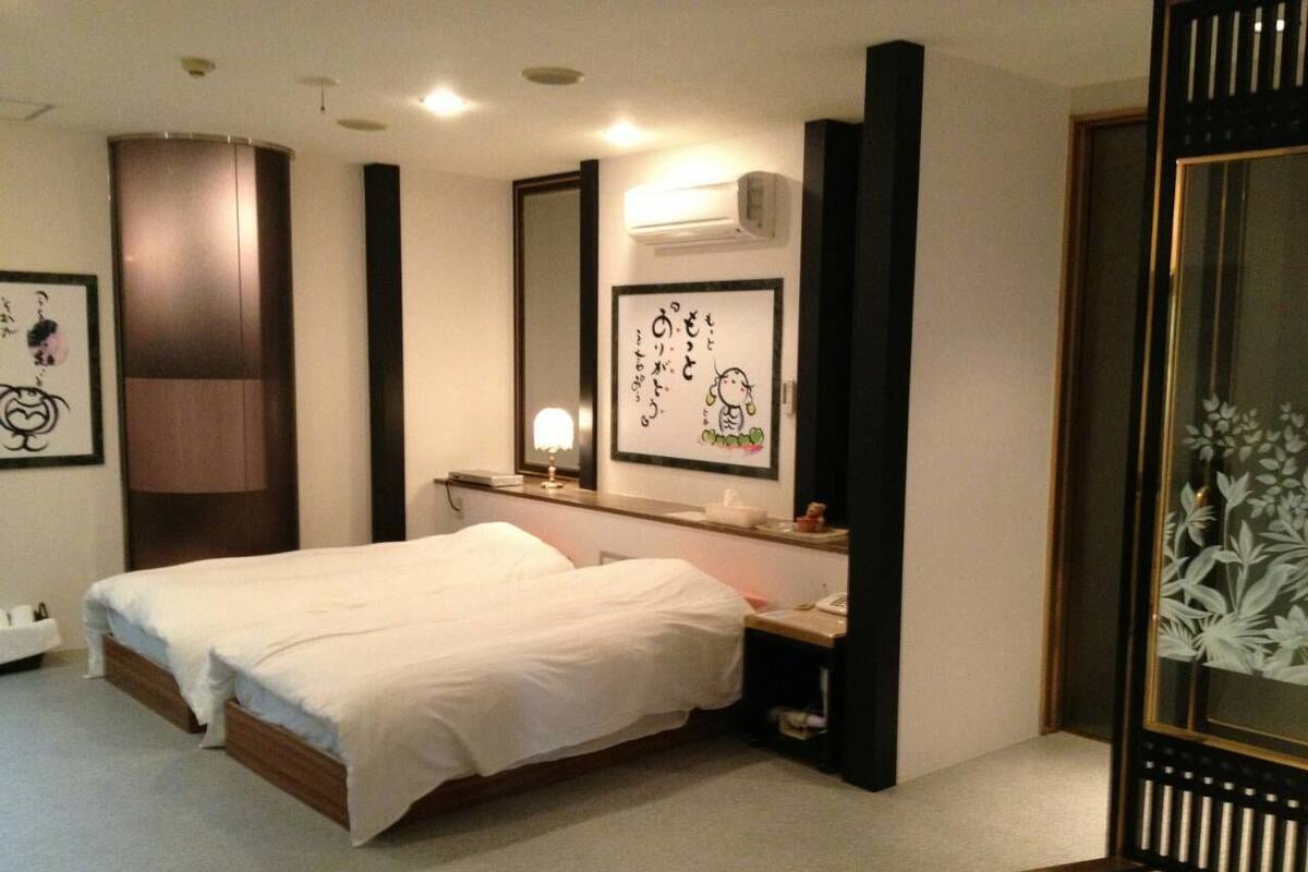 A bedroom with a bed, bedside table, and a mirror.
