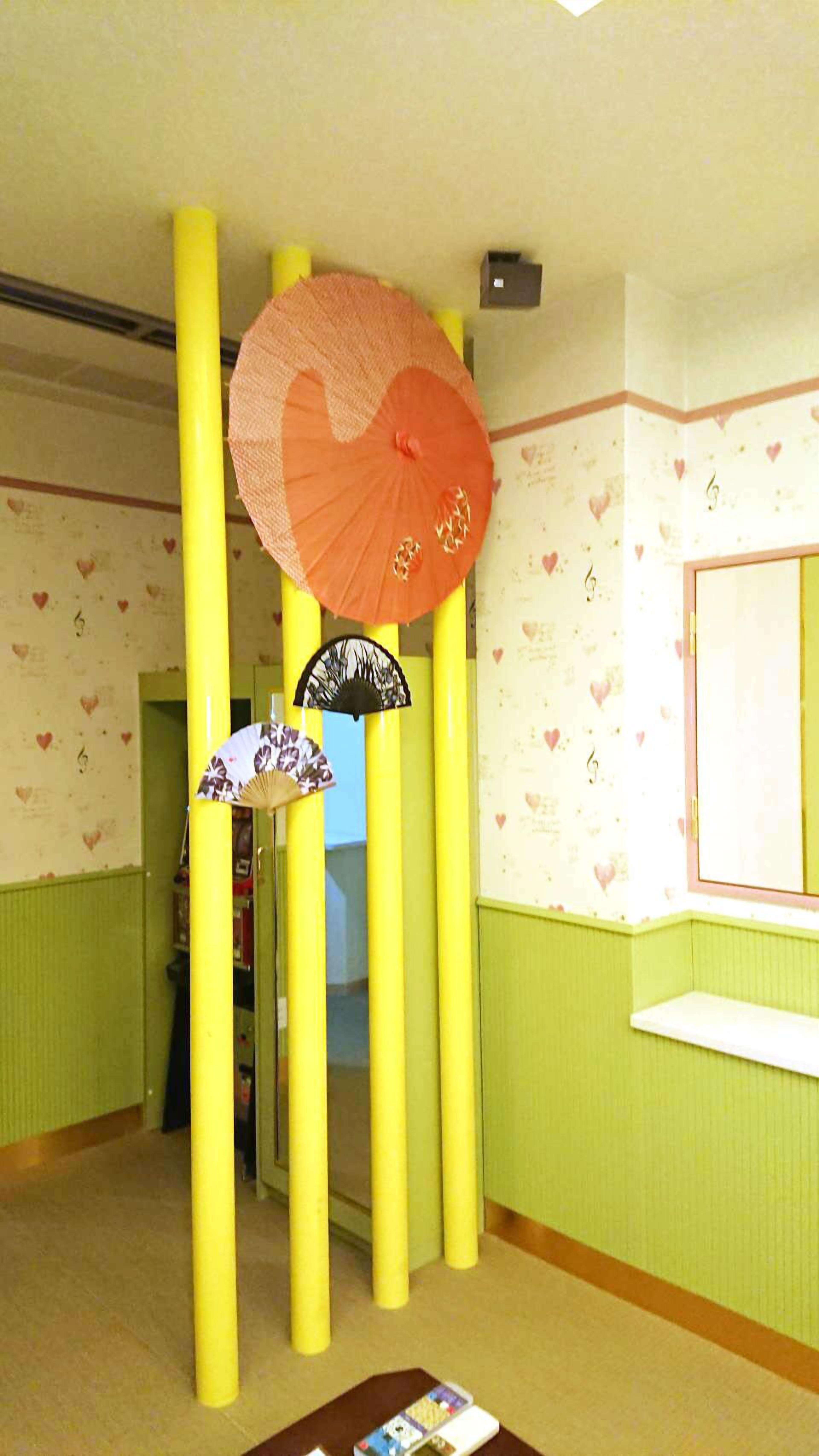 Una habitación con pilares amarillos, un espejo y una pared con diseños de corazones.
