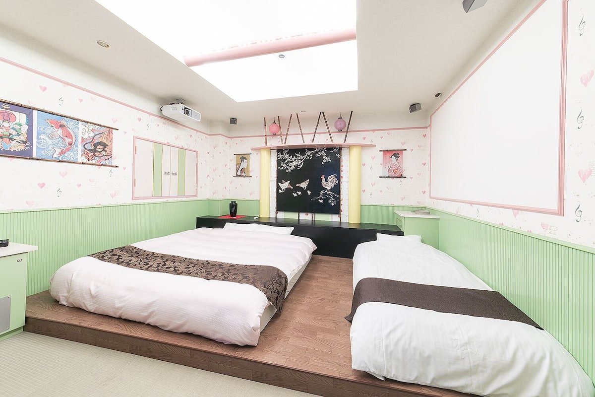 A bedroom with two beds, a skylight, and artwork on the walls.