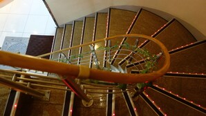 A spiral staircase with a handrail, metal railings, and red LED lights. - Hotel To (Wakayama)