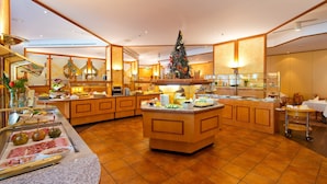 Un bufé hotelero con un árbol de Navidad, distintas estaciones de comida y una isla central.