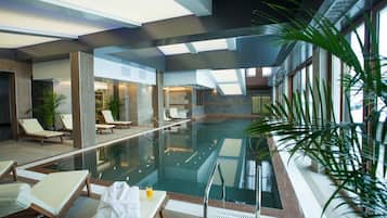Una piscina techada, sillones reclinables de piscina