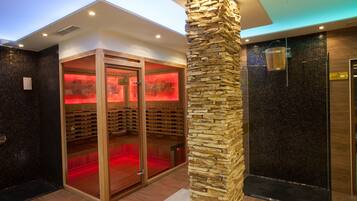 Un moderno espacio de spa con un pilar de piedra, una sauna y un baño de vapor.
