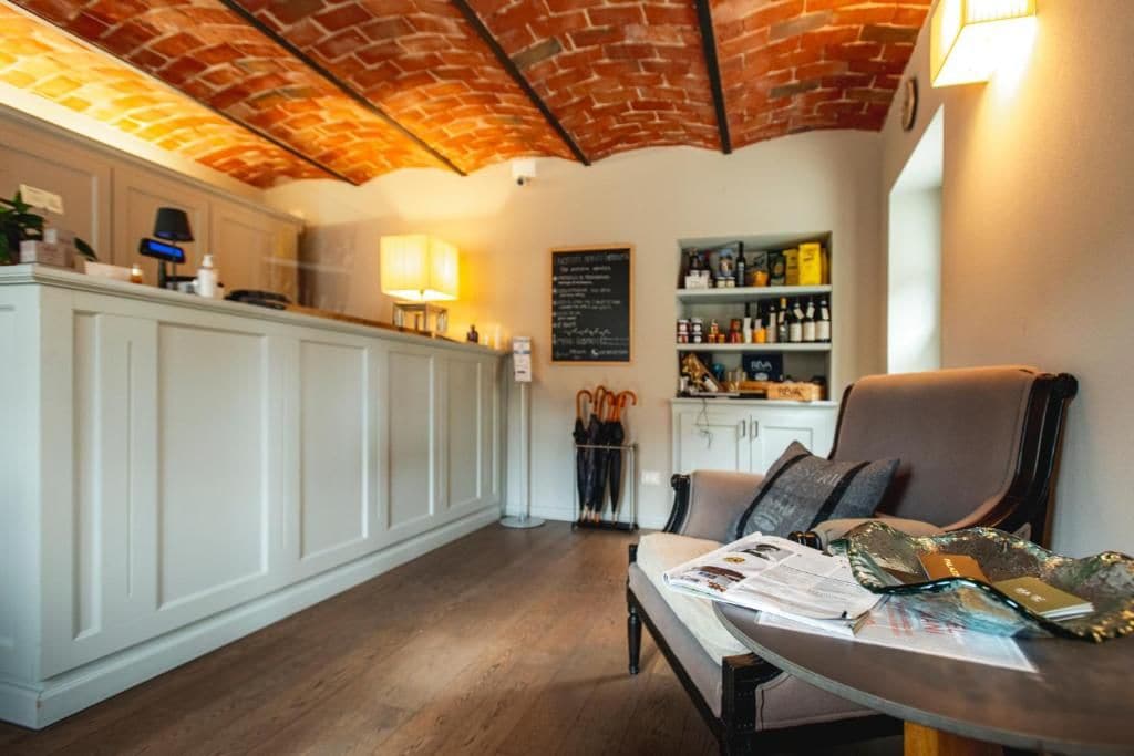 Un espace bar avec un plafond en briques, des meubles blancs et un coin salon comprenant une table et des chaises.