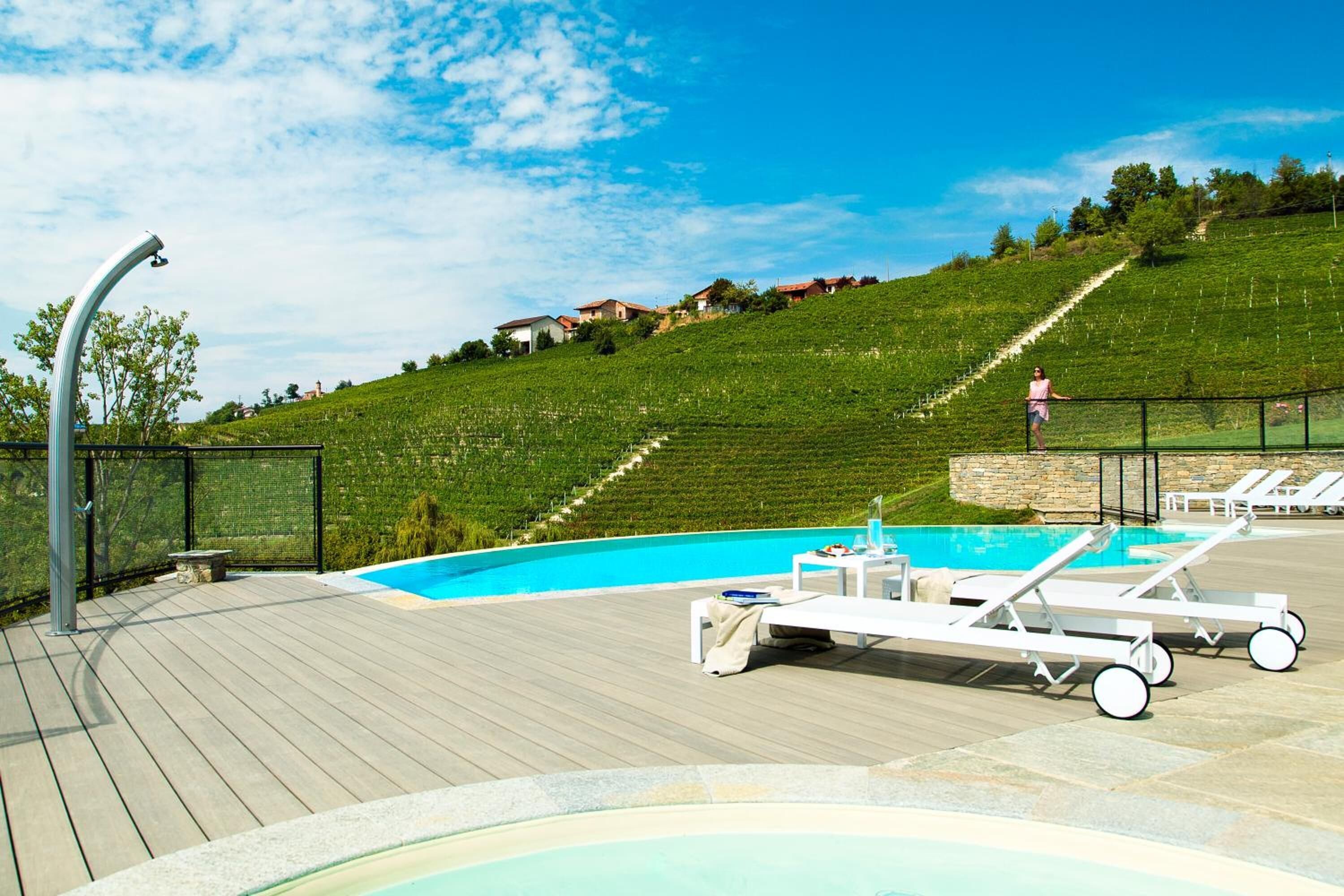 A swimming pool with lounge chairs and a wooden deck.