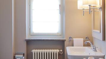 Ein Badezimmer mit Toilette, Waschbecken, Fenster und Heizkörper.