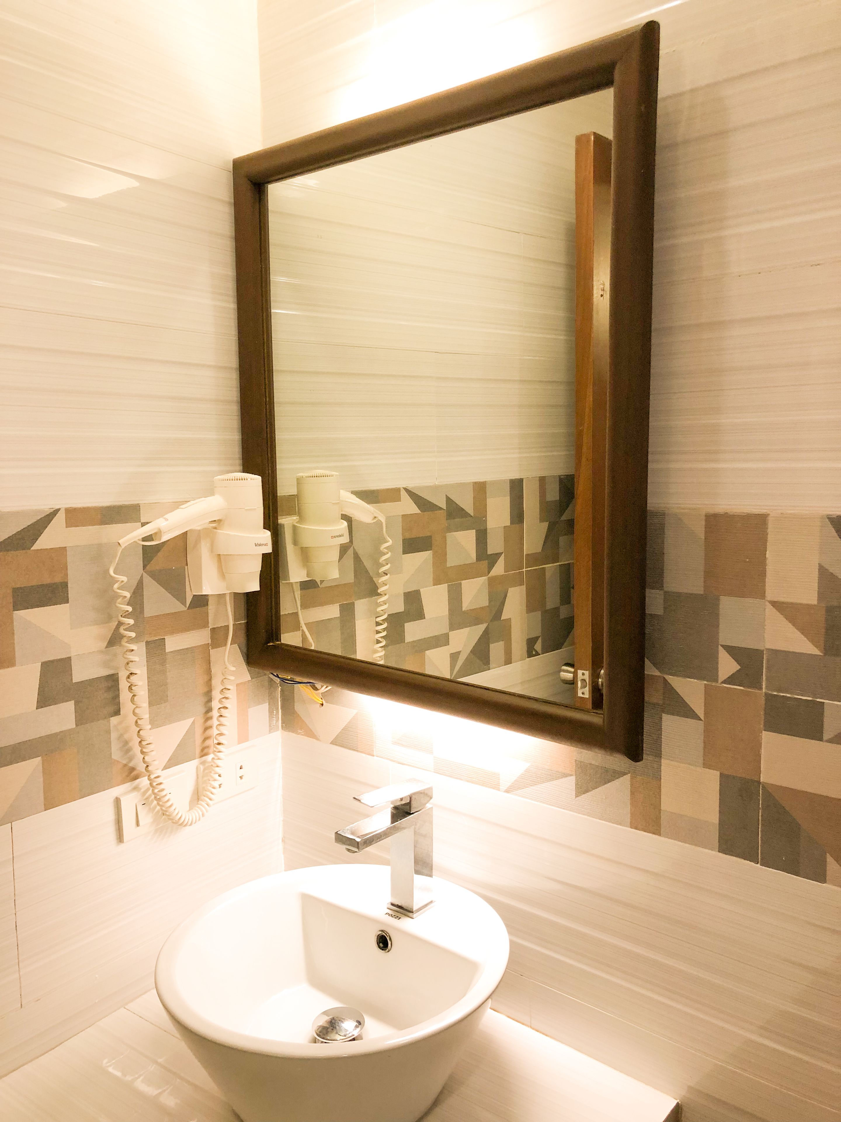A bathroom with a white sink, a mirror, and a telephone.