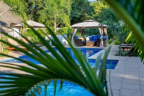 A pool area with lounge chairs and a gazebo. - Ngoma Zanga Lodge (Livingstone)