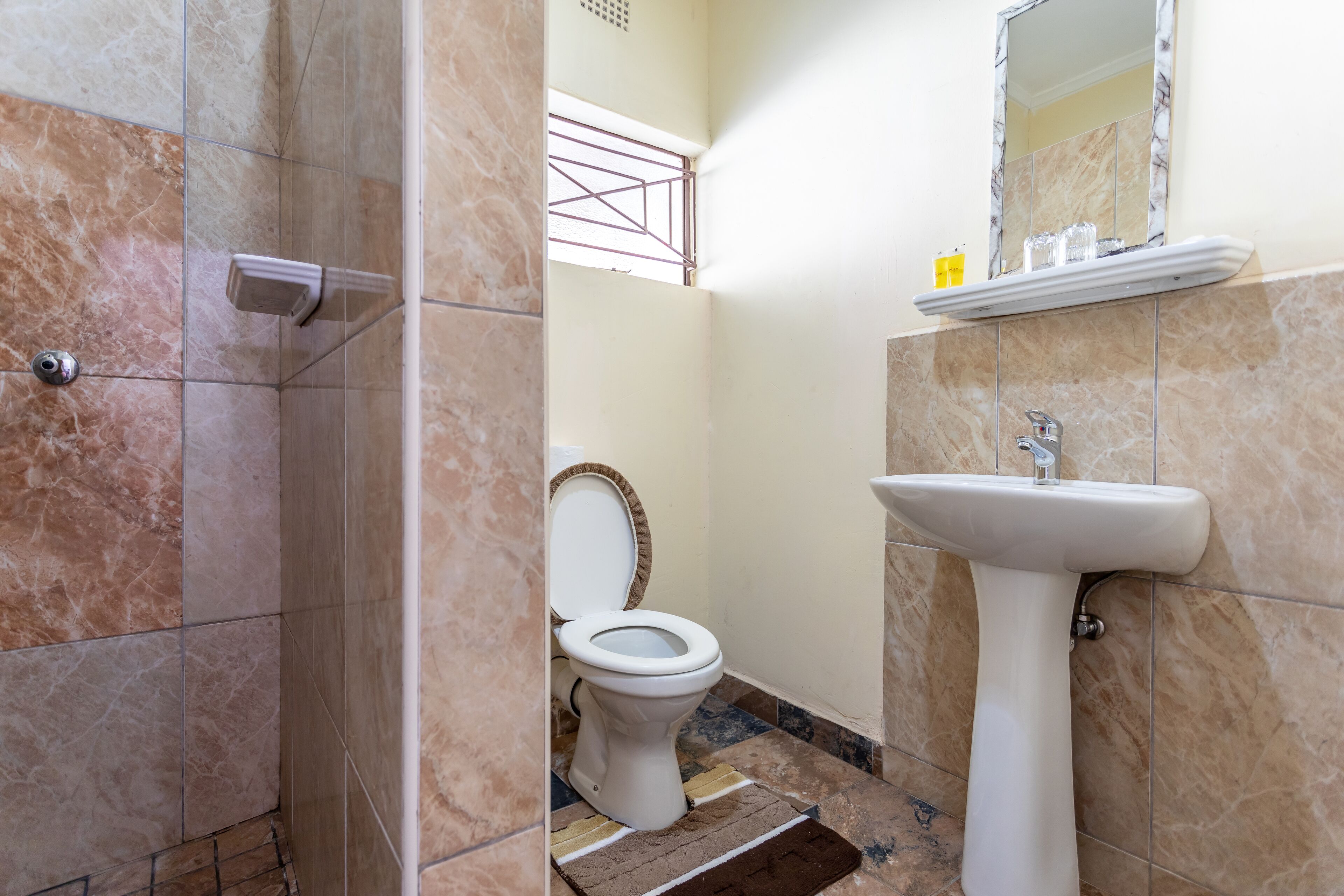 Un baño con inodoro, lavamanos y zona de ducha.