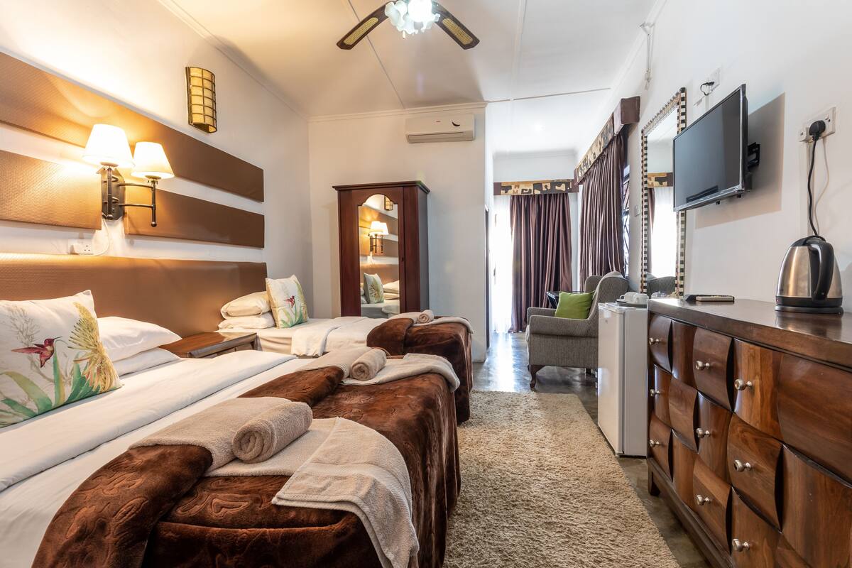 Een hotelkamer met een groot bed, een bureau, een dressoir, een televisie en een kleine koelkast.