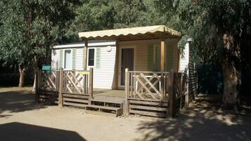 A small, single-story building with a porch and a wooden fence.