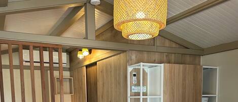 Une chambre moderne avec une armoire en bois, un canapé et un luminaire suspendu.