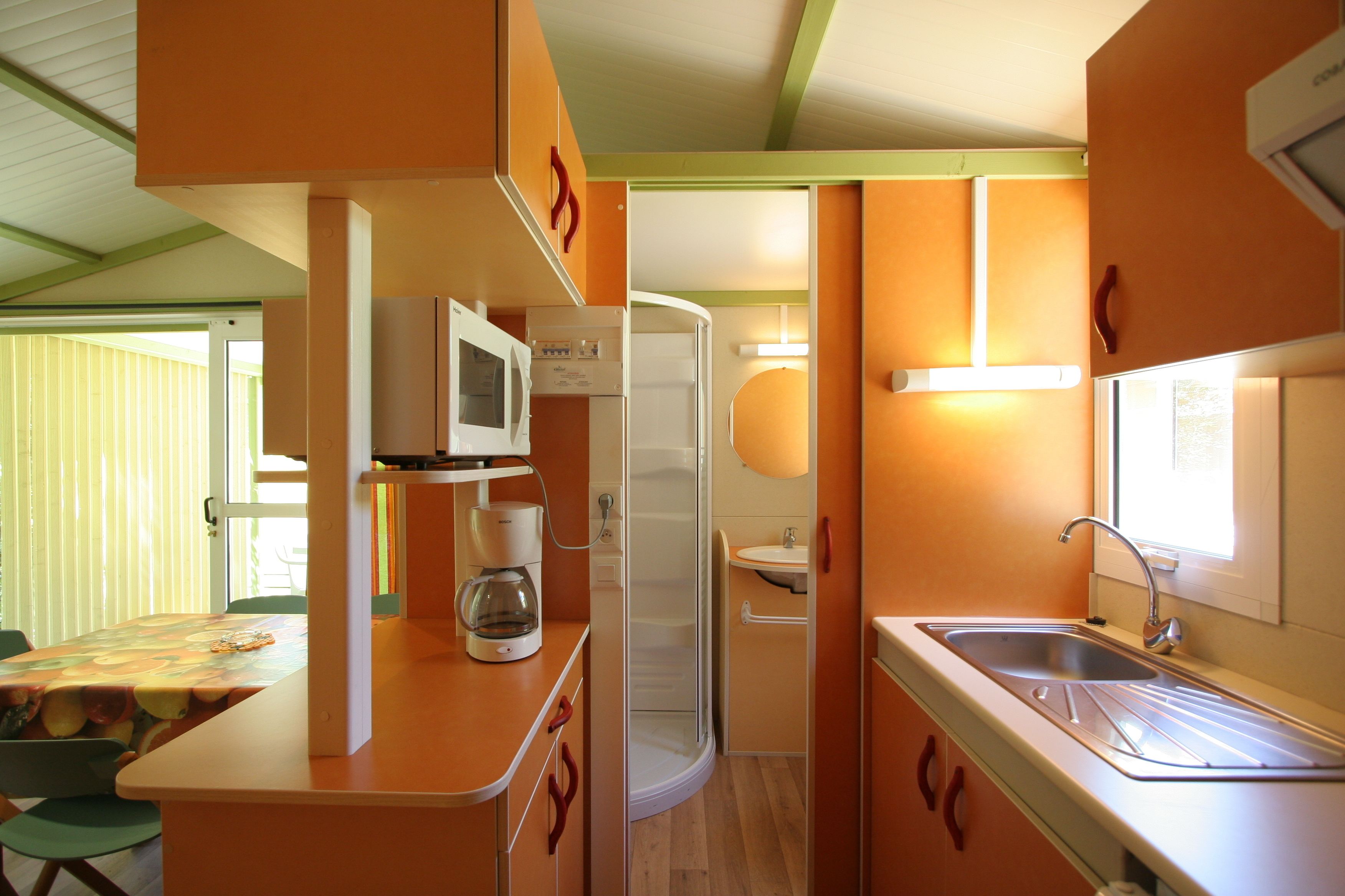 A compact kitchen with a microwave, coffee maker, and sink.