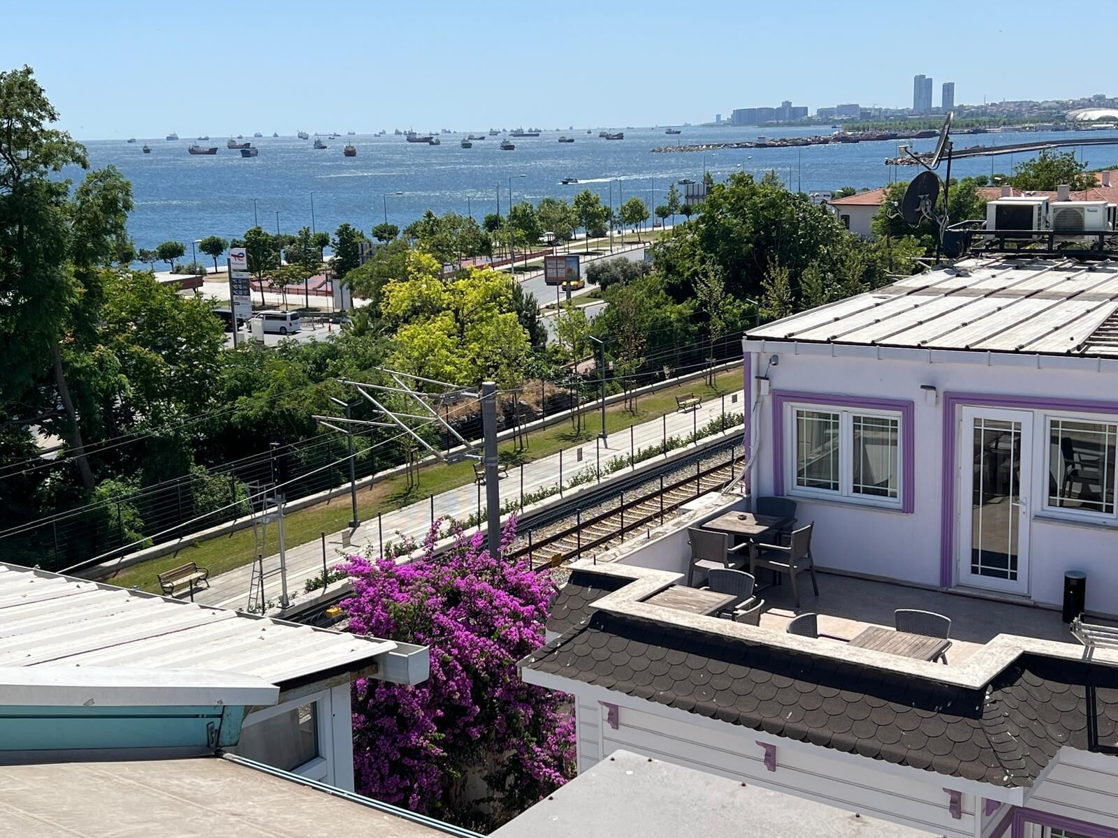 A residential building with a view of the sea and a railway track.