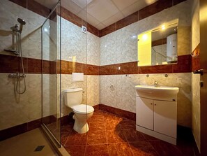 Estúdio família, vista parcial para o mar | Banheiro | Chuveiro, secador de cabelo, toalhas de banho, sabonete
