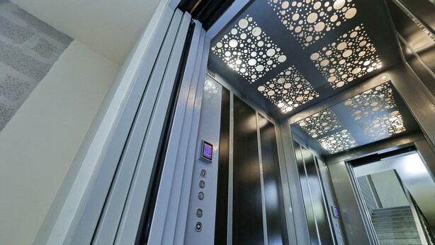 An elevator interior with a modern design, including a patterned ceiling and a digital control panel. - My Apartments Yerevan (Yerevan)