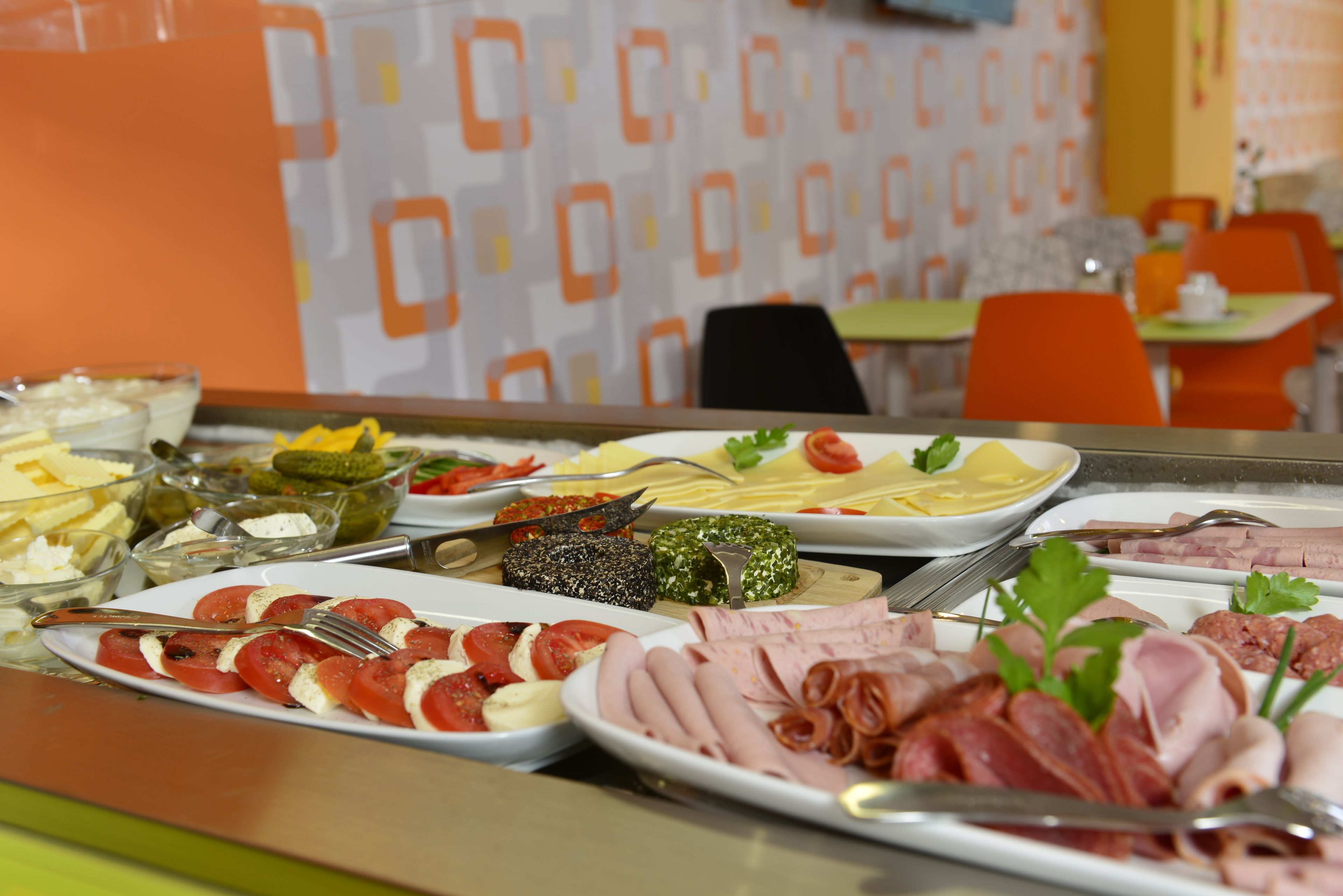 Un bufet amb diferents aliments, com ara carns, formatges i verdures.