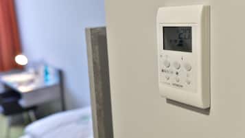 A digital thermostat on a wall, displaying a temperature of 20 degrees Celsius.