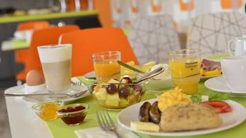 A breakfast table with various food items and drinks.