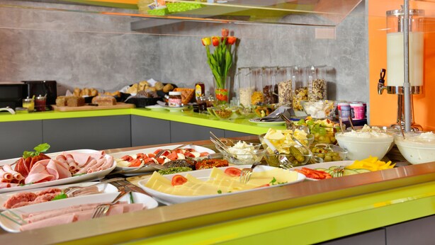 A buffet with various food items and a glass display case.
