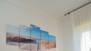 A bedroom with a bed, a bedside table, and a window with curtains. - Residence Verbena (Rimini)