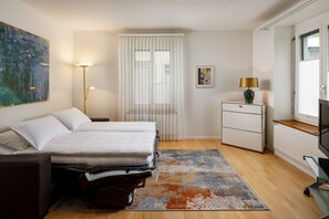 Suíte, 1 quarto | Área de estar | TV de tela plana 45 polegadas com canais a cabo, TV, escritórios