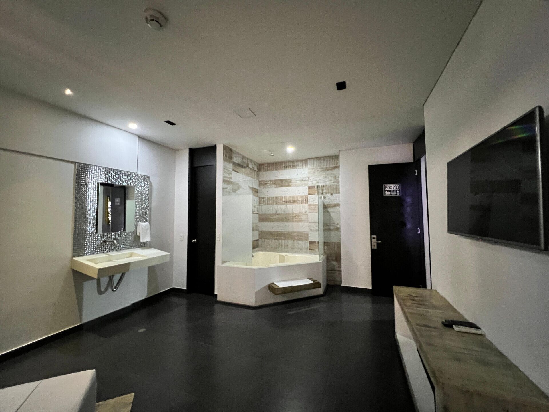 Un baño moderno con un espejo grande, una bañera y un tocador.