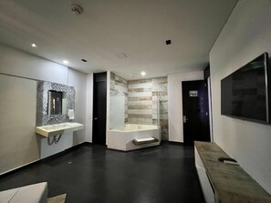 Een moderne badkamer met een grote spiegel, een badkuip en een wastafelmeubel.
