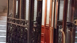 A metal gate with intricate designs, leading to a wooden door with a red carpet. - MORE Cola di Rienzo B&B (Rome)