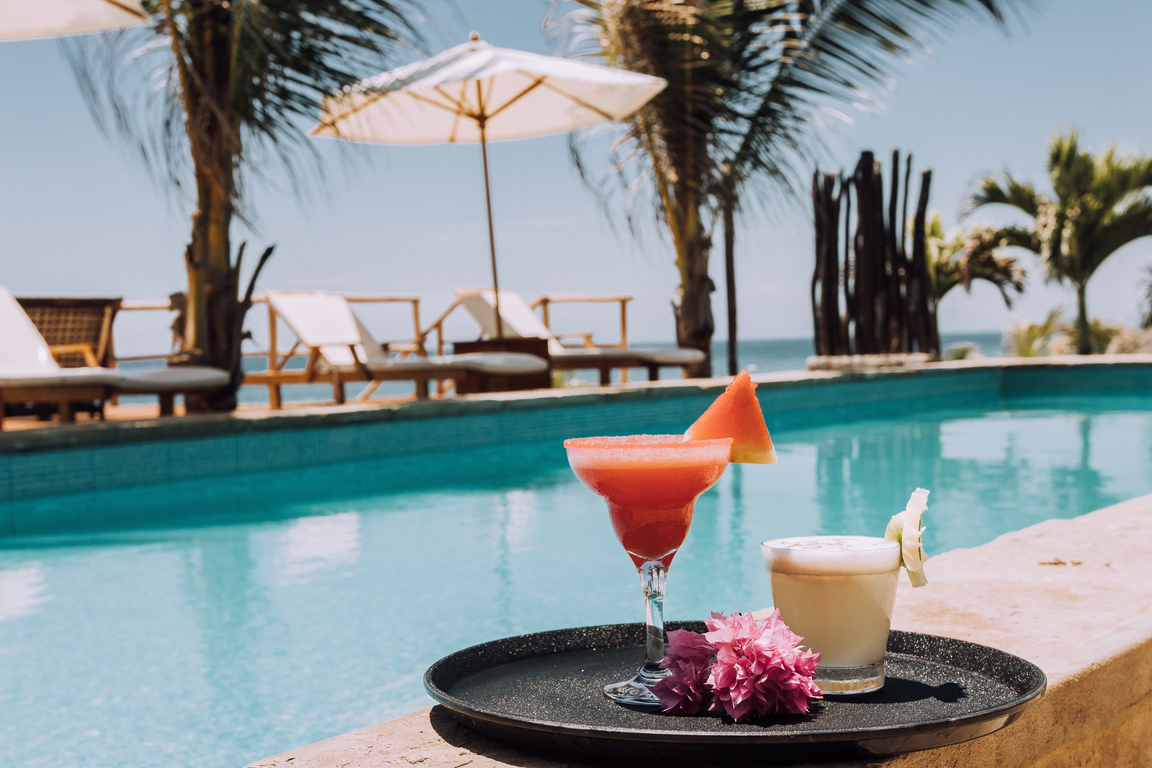 Una piscina al aire libre, sillones reclinables de piscina