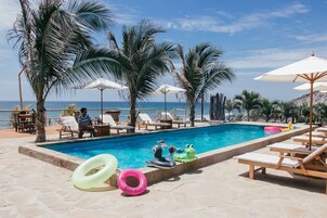 Una piscina al aire libre, sillones reclinables de piscina