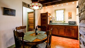 Un espace repas comprenant une table en bois, des chaises et un luminaire suspendu.