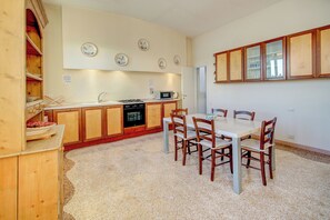 Una cocina compacta con comedor, armarios de madera y microondas.