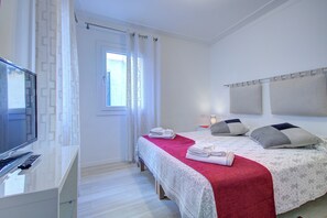 Ein Hotelzimmer mit Bett, Fernseher und Schreibtisch.