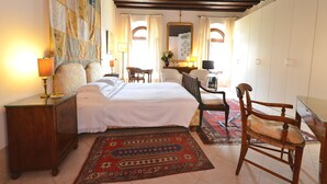 Un dormitorio con una cama grande, muebles de madera, un espejo y un tapete estampado.