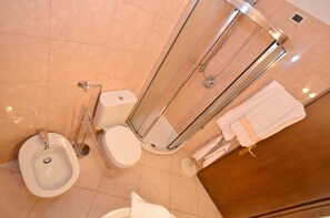 A modern bathroom with a bidet, toilet, and glass-enclosed shower. - TRIBUNO Grand Canal (Venice)
