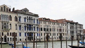 Una hilera de edificios históricos con ventanas arqueadas y balcones a lo largo de un canal.