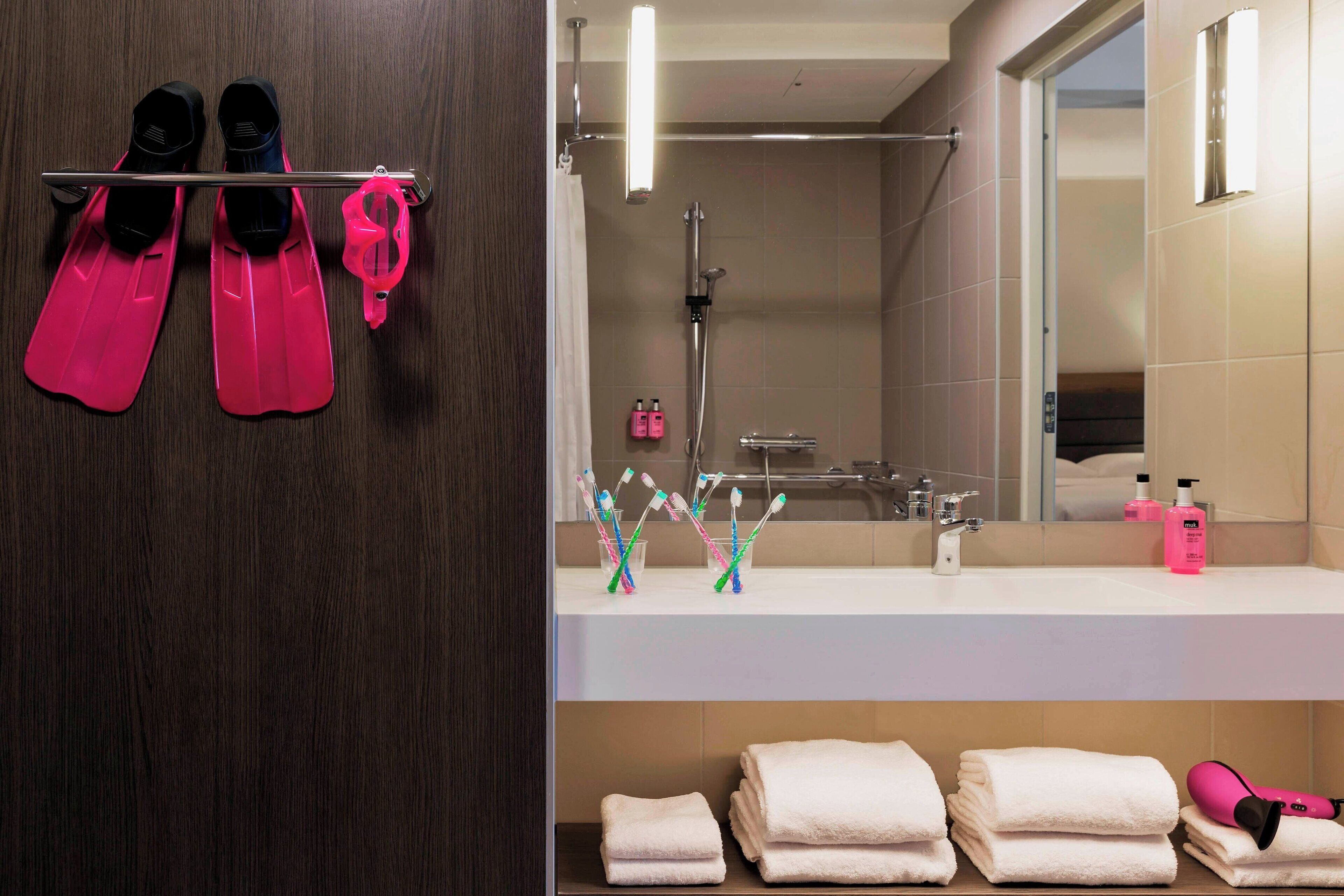 A bathroom with a mirror, sink, and towel rack.
