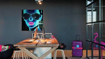 Relax in a stylish space with a large desk, comfortable seating area, and a glass partition offering a view of the outside.