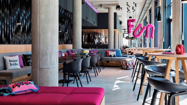 Un interior moderno con una zona de bar, asientos y un letrero de neón.